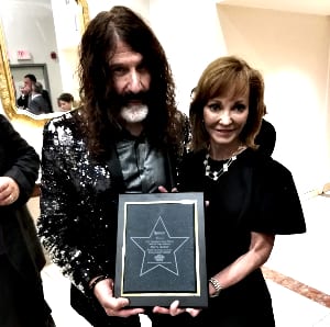 L R Pierre Robert and Caroline Beasley holding an award together